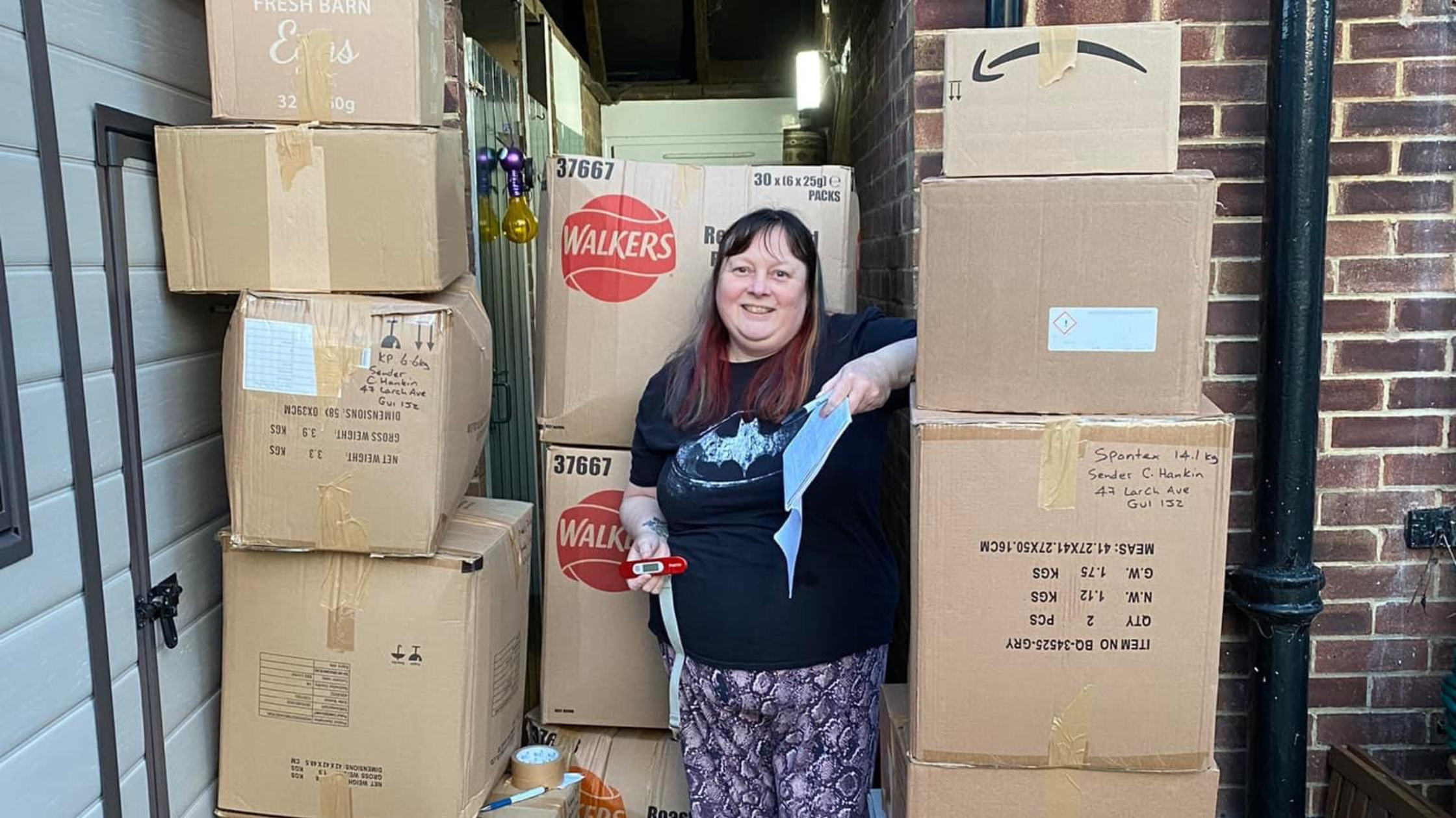 Image of Cheryl Hankin, who runs CTK Recycling Guildford, standing in her garage surrounded by boxes of recycling
