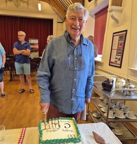 Image of CPRE Surrey President Anthony Isaacs cutting their centenary cake