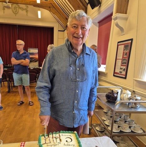 Image of CPRE Surrey President Anthony Isaacs cutting their centenary cake