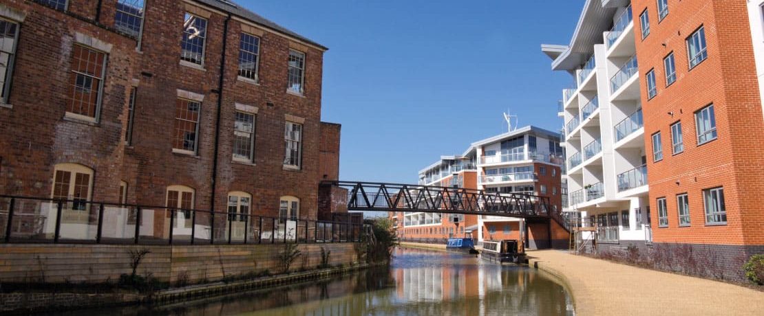 A combination of old and new buildings with a canal passing between them