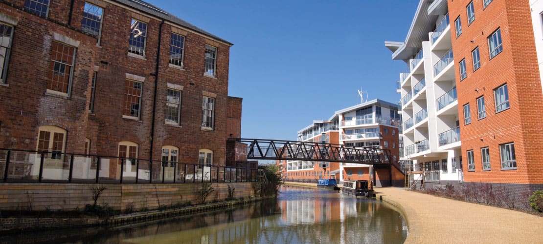 A combination of old and new buildings with a canal passing between them