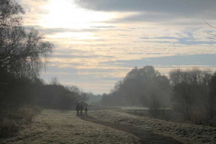 A family on a frosty walk in the mist