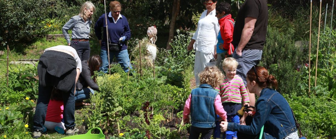 Adults and children in a community garden