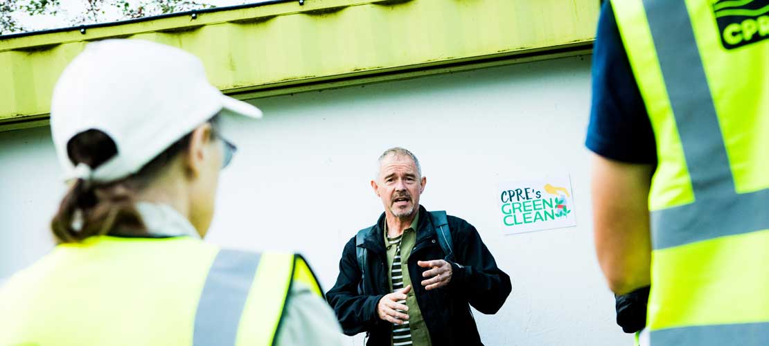 A CPRE volunteer talks to others, who wear branded high vis jackets
