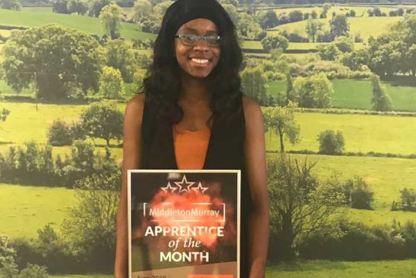 Ketsia Tampo, CPRE apprentice, holds a certificate saying Apprentice of the Month