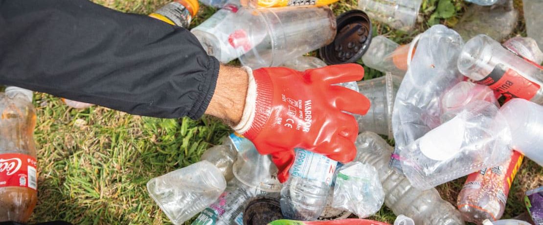 Gloved hand sorting through bottles