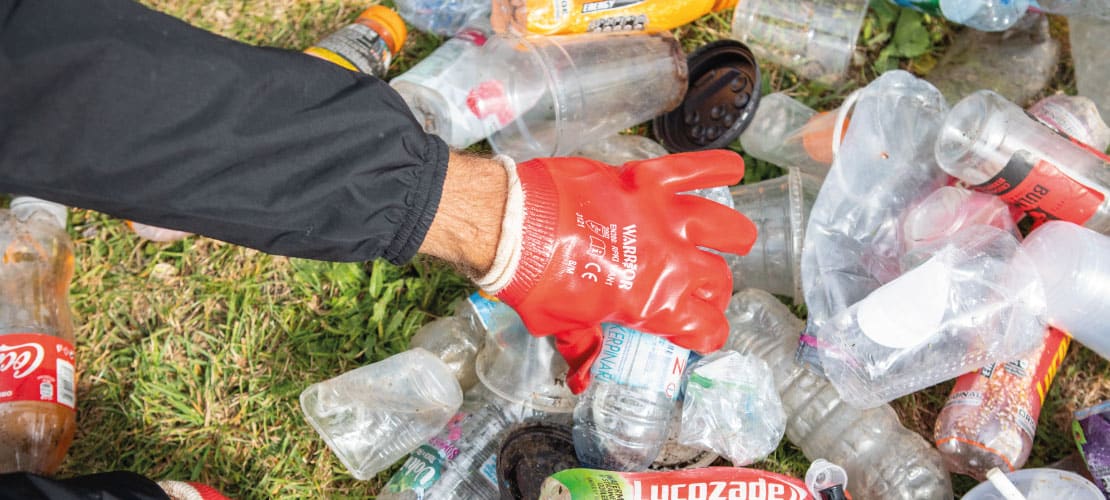 Gloved hand sorting through bottles