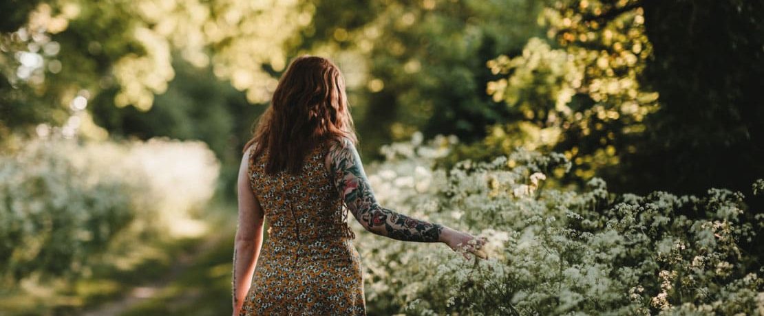 Woman walking past hedgerow