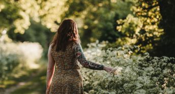 Woman walking past hedgerow