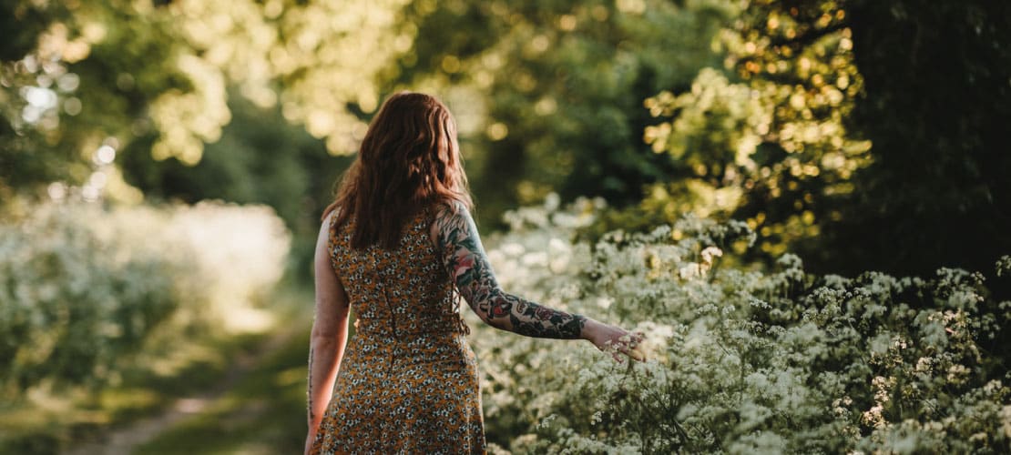 Woman walking past hedgerow