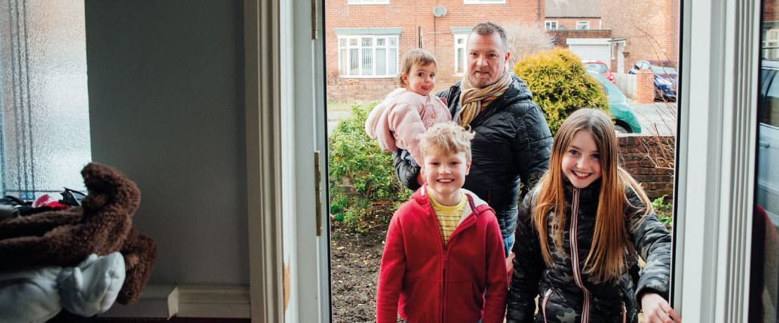 Family walking through door of house