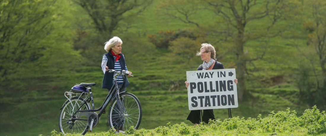A voter with her bicycle on way to vote at a rural polling station in Shirwell, Devon.