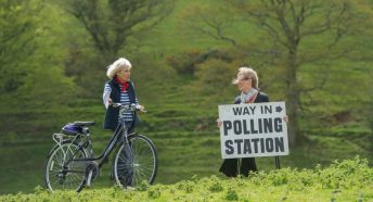 A voter with her bicycle on way to vote at a rural polling station in Shirwell, Devon.