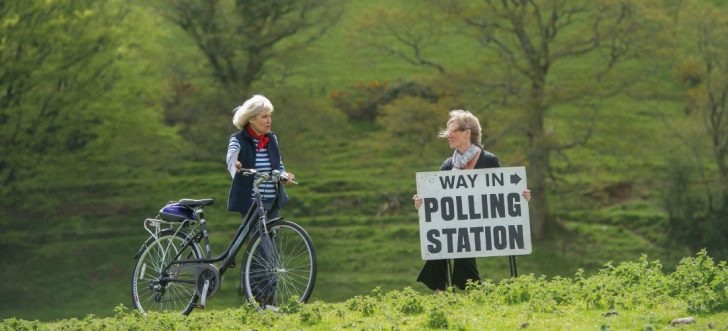 A voter with her bicycle on way to vote at a rural polling station in Shirwell, Devon.