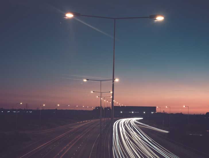 A road with streaks of headlights and street lights