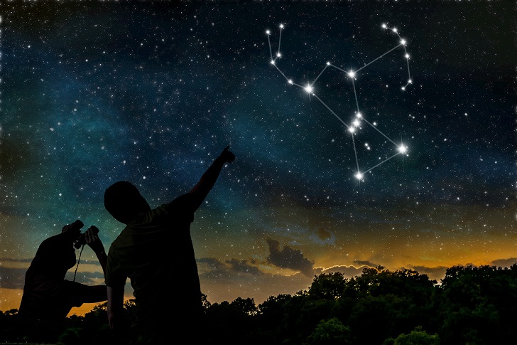 Stargazers pointing at the constellation of Orion