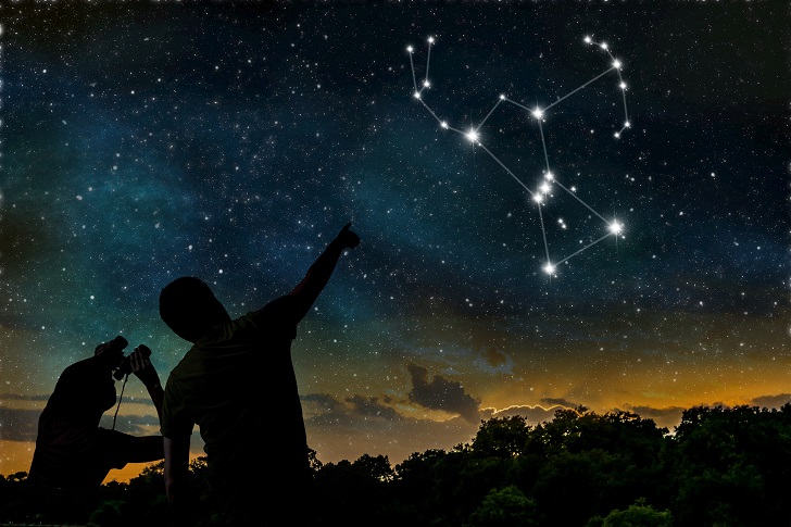 Stargazers pointing at the constellation of Orion