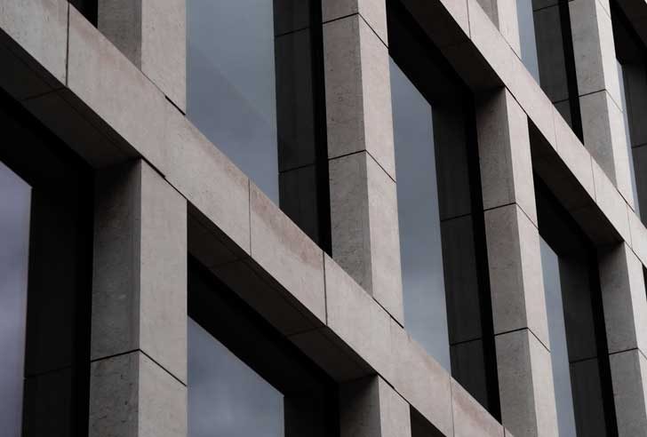A grey concrete building with dark windows