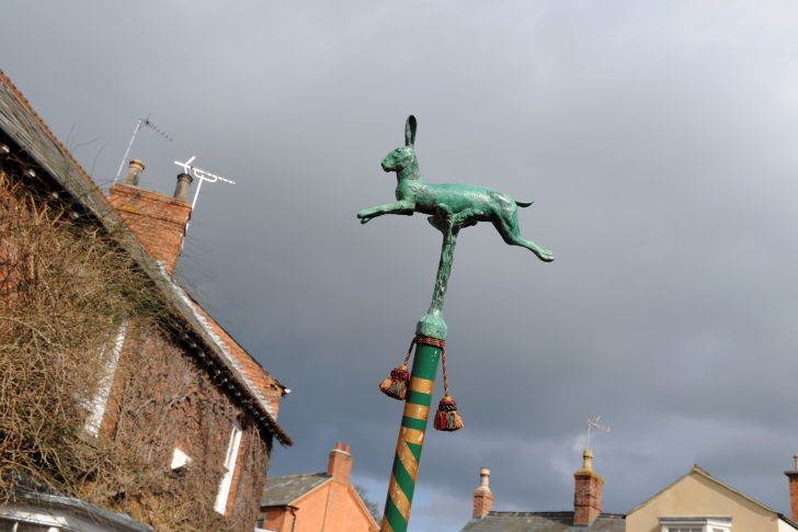 A metal hare on a pole is carried through the village of Hallaton