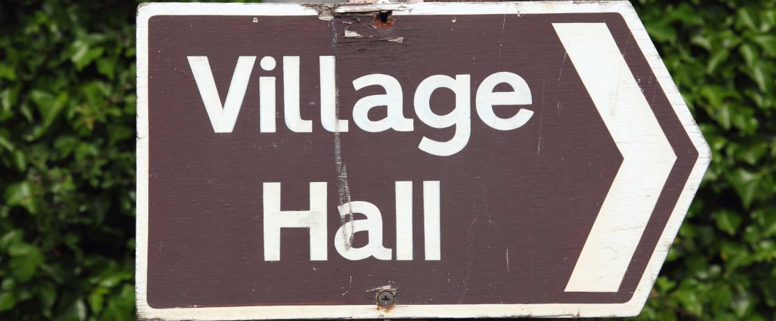 A brown village hall sign