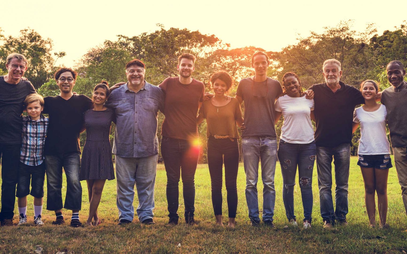 Line of people in green space at sunset