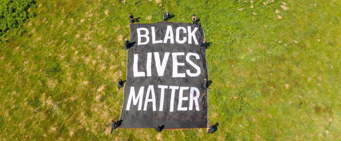 Overhead view of Black Lives Matter banner and people kneeling