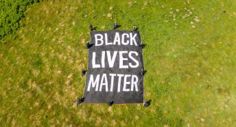 Overhead view of Black Lives Matter banner and people kneeling