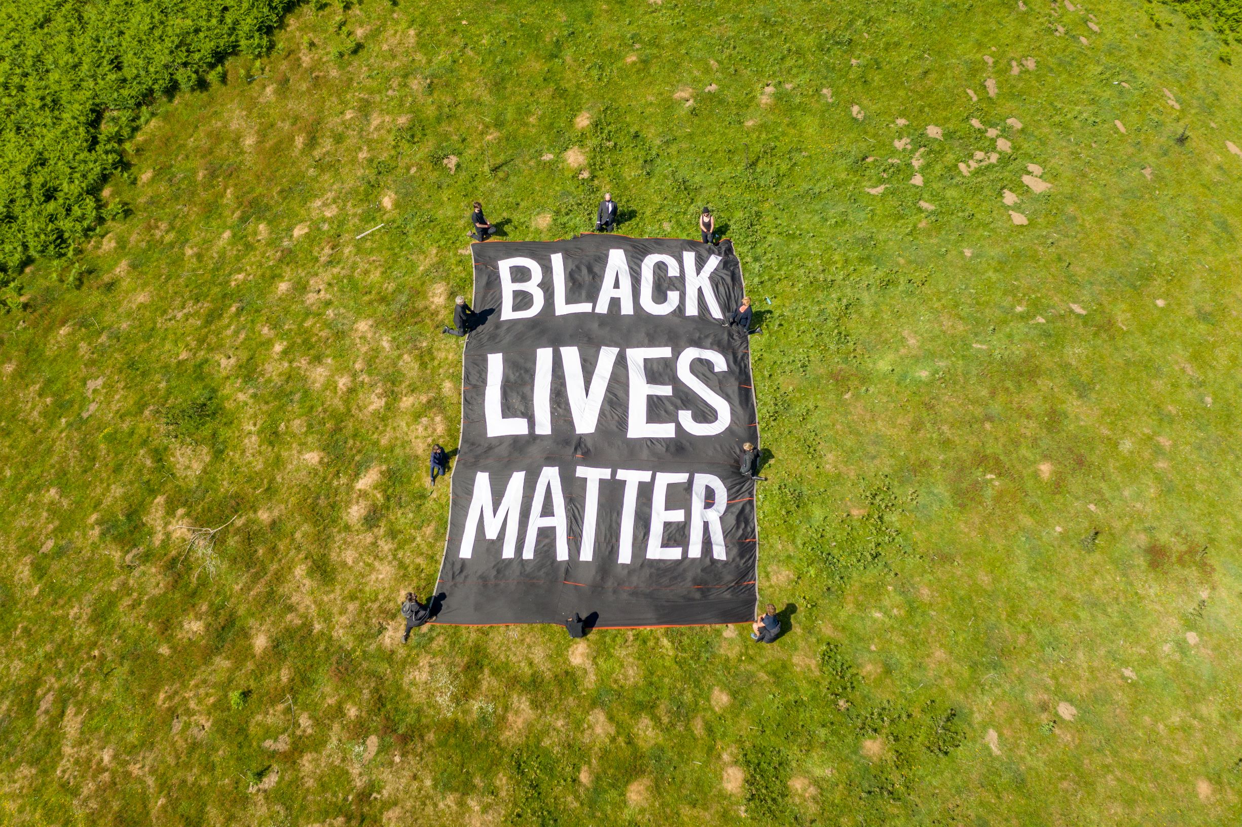 Overhead view of Black Lives Matter banner and people kneeling