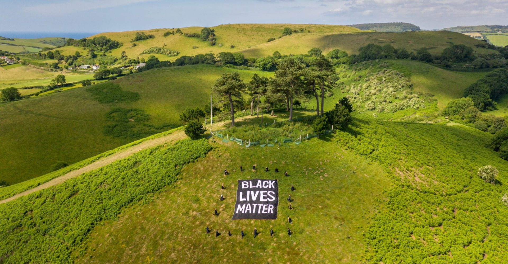 Black Lives Matter banner in Dorset landscape with protesters