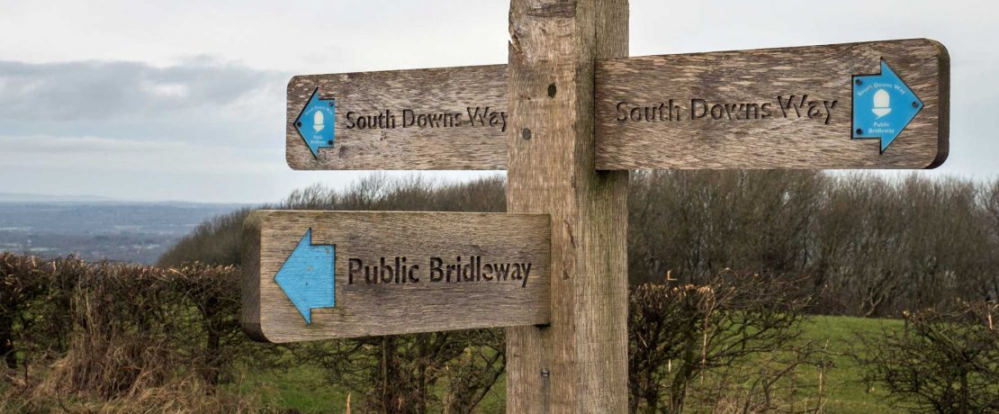 A wooden fingerpost pointing to South Downs Way