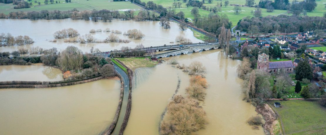 Flooded countryside scene with brown water covering fields