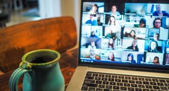 Laptop with cup of tea and other callers on screen