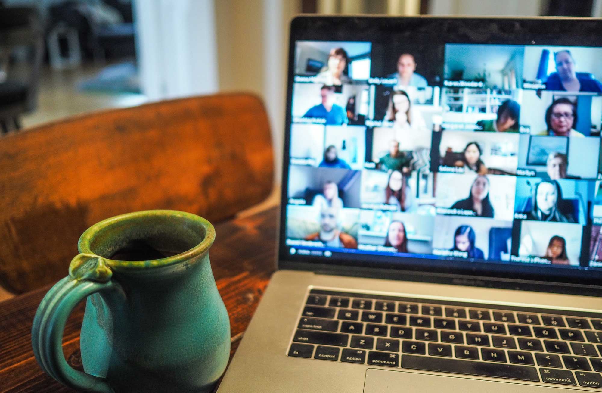 Laptop with cup of tea and other callers on screen
