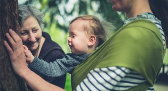 Grandmother, mother and child touch large tree