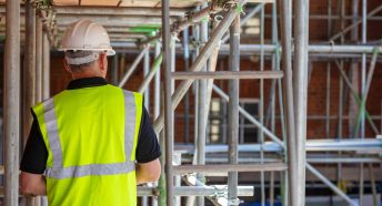 A builder in a high visibility vest on a building site