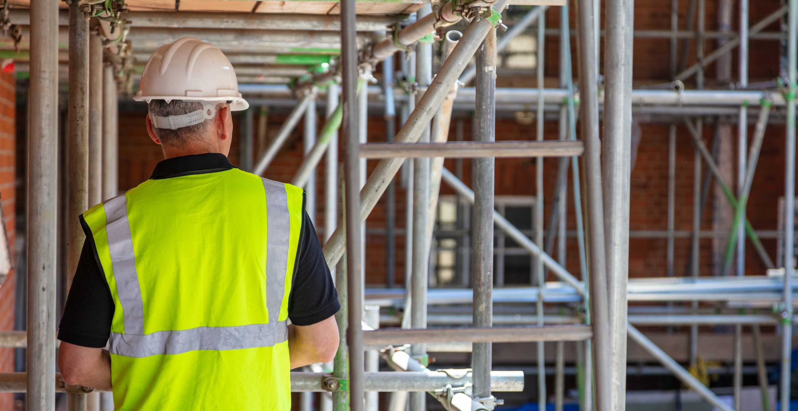 A builder in a high visibility vest on a building site
