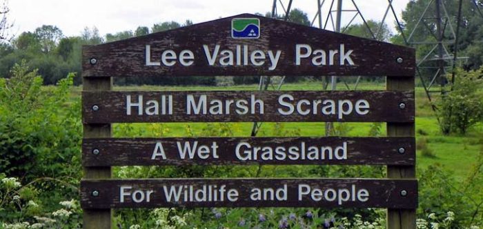 A wooden sign announcing a park for wildlife and people