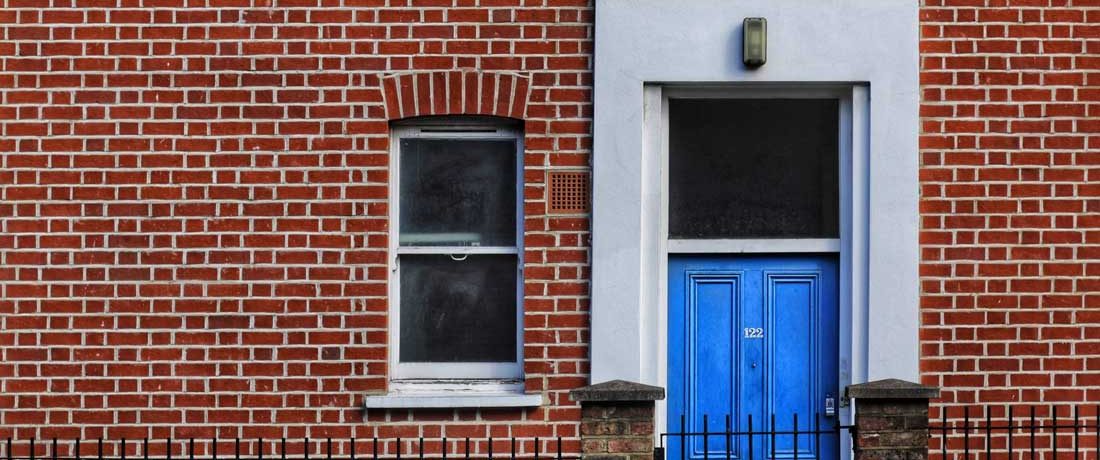 A bright front door in a brick wall
