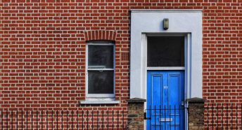 A bright front door in a brick wall