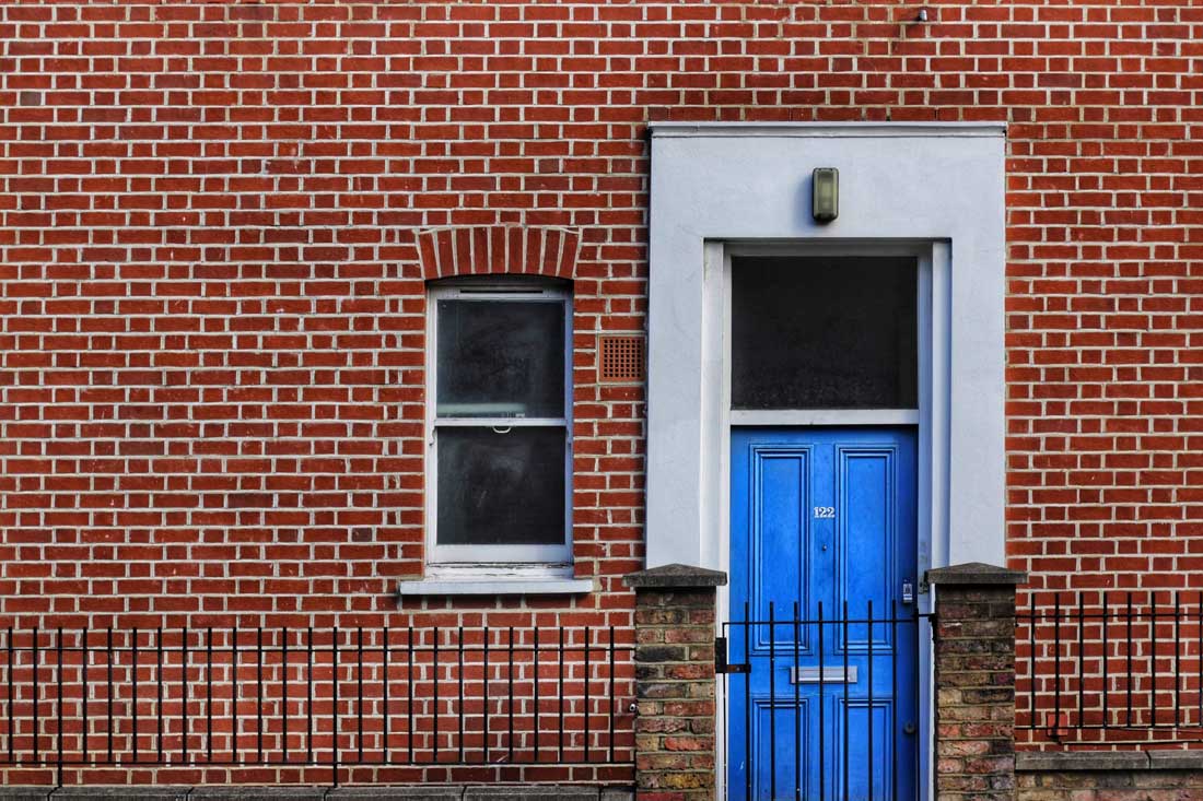 A bright front door in a brick wall