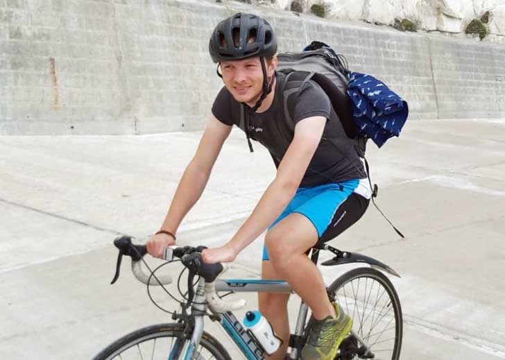 A man on a bike on a seaside path