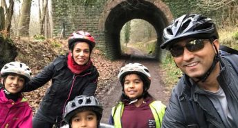 A family pose on bikes on a wooded track