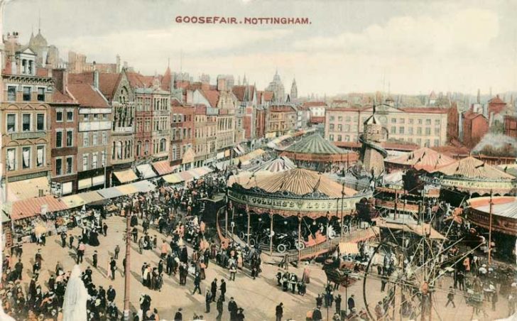 A tinted postcard showing a funfair from above