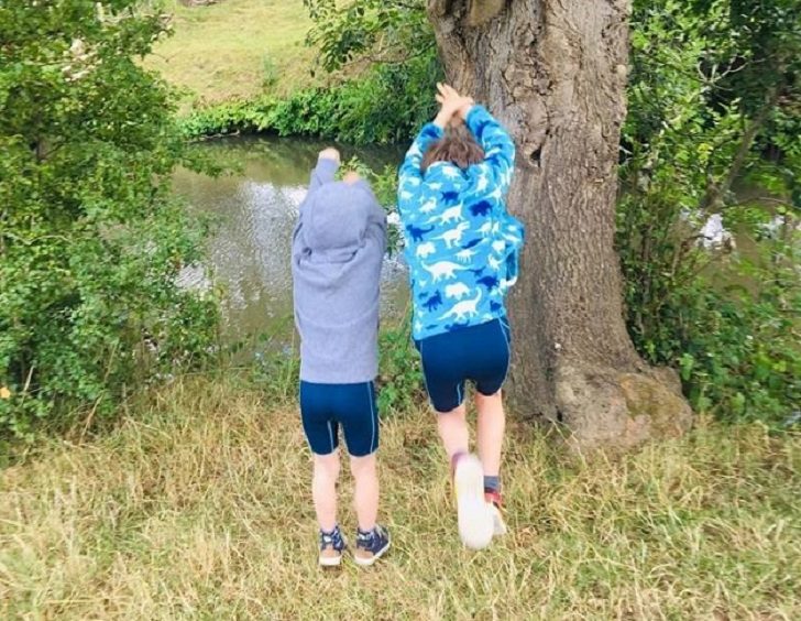 Two boys pretending to dive into river