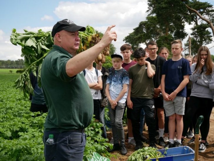 A farmer talking to a group of young people about his crops