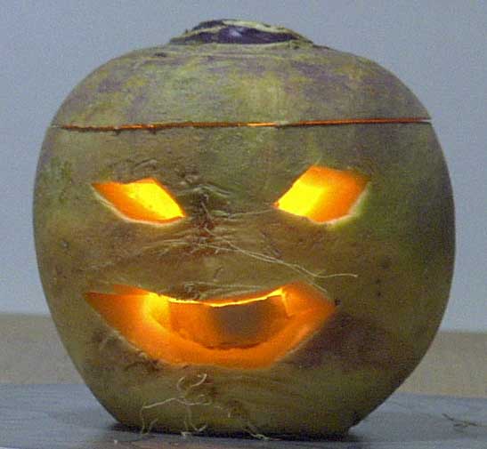 A turnip hollowed out and with a carved face and candle inside