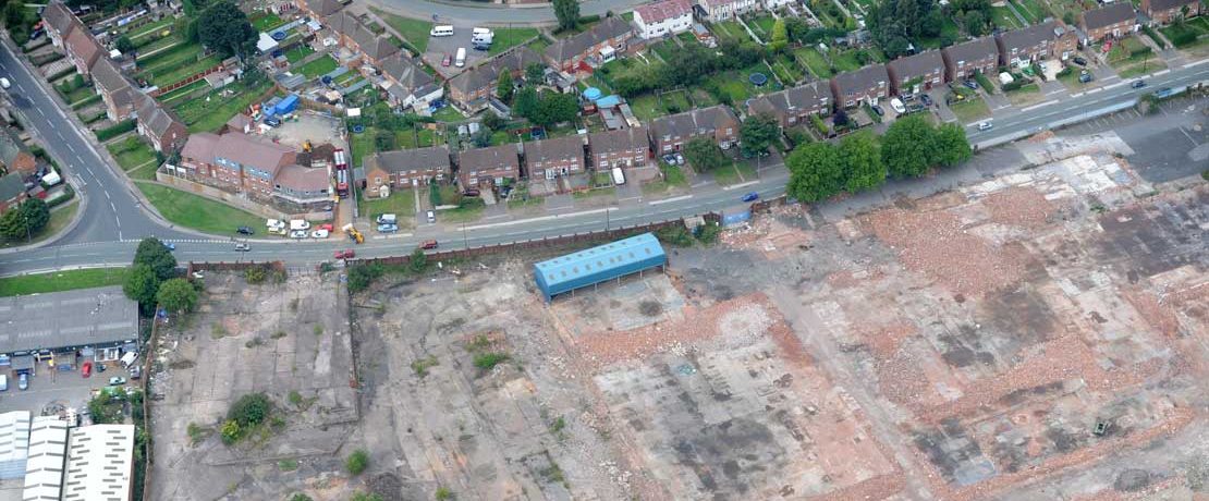 An aerial shot of a large area of disused land beside housing