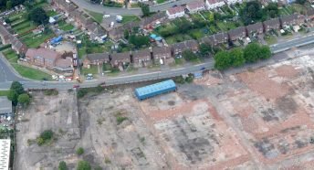 An aerial shot of a large area of disused land beside housing