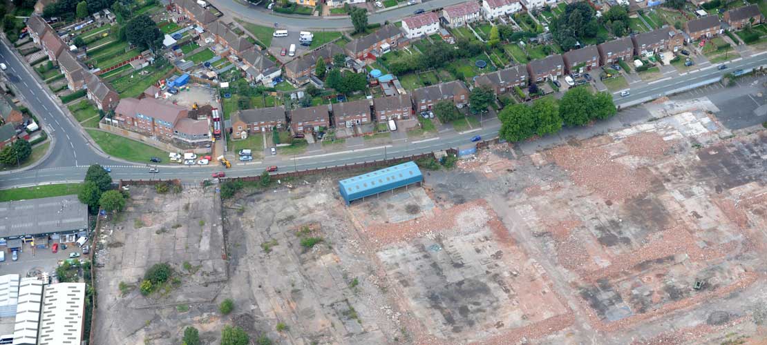 An aerial shot of a large area of disused land beside housing