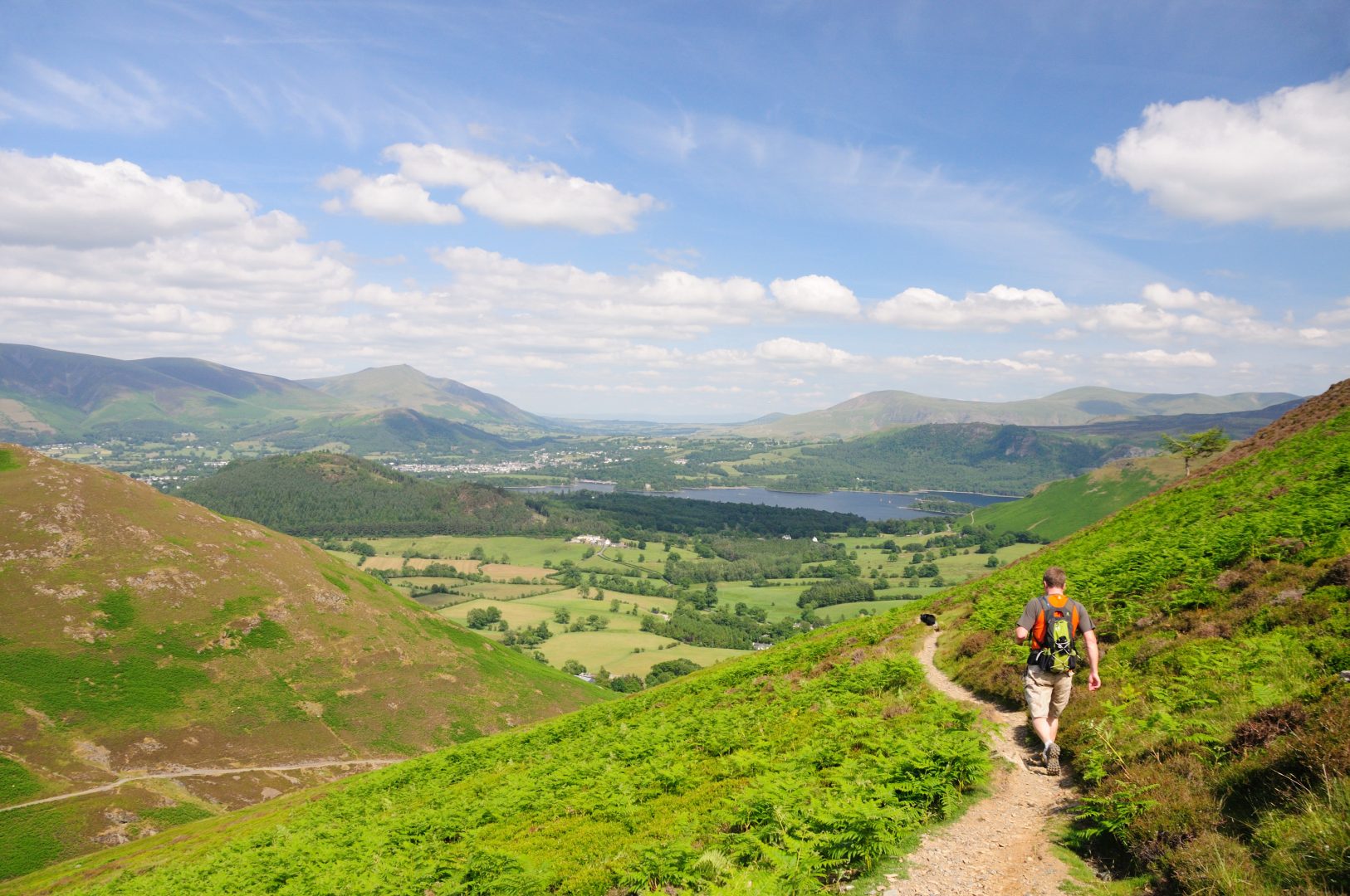 Lone walker looking on path high above lake